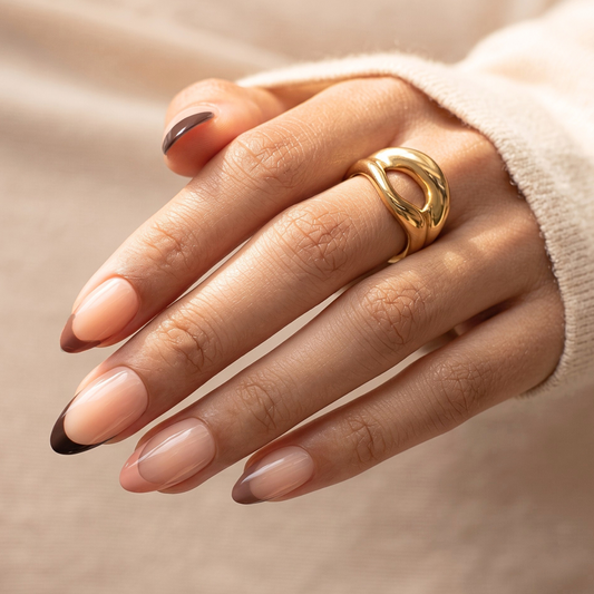Short almond soft gel press-on nails, sheer nude with glossy brown French tips.