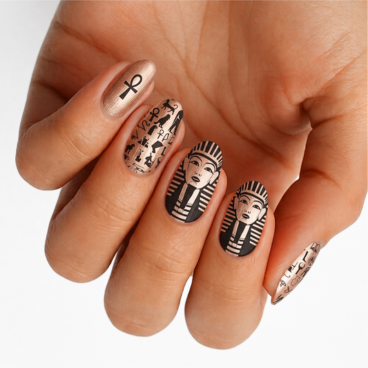 Metallic rose gold nail wraps with black Egyptian pharaoh, ankh, and hieroglyph designs.