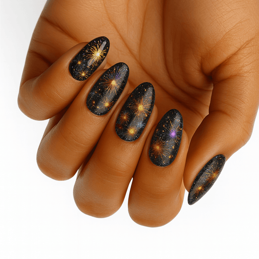 Black nail wraps with golden fireworks pattern on hand showing bonfire night design