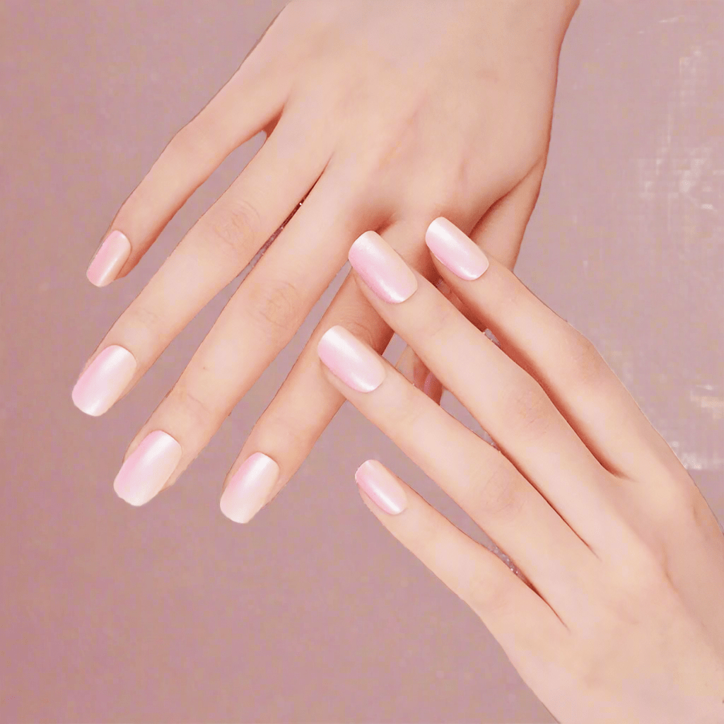 Hands displaying glossy pink sunset ombre nail art with coral gradient nail wraps