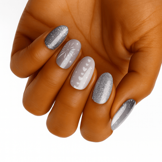 Hand wearing silver glitter and grey geometric nail wraps with festive winter patterns
