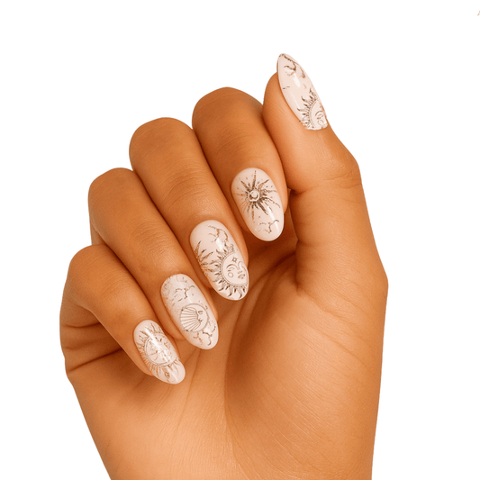 Nude gel nail wraps with rose gold celestial fortune telling symbols on hand