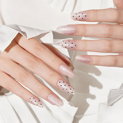 Glittery pink press-on nails, almond shape, with black polka dot accents