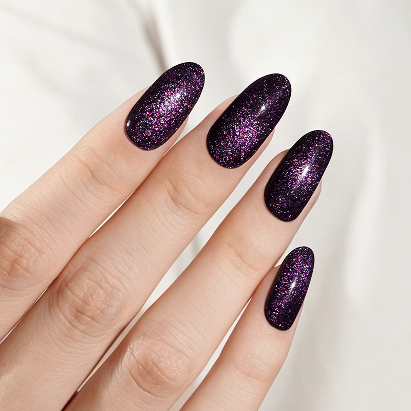 Deep purple glittery press-on nails with shimmering galaxy-effect finish, almond shape