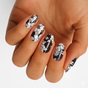 Black nail wraps with white floral line art and glossy finish on almond nails
