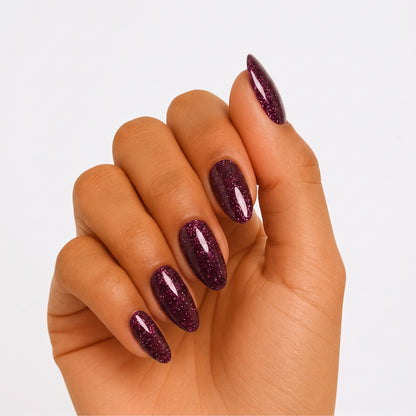 Deep purple-red glitter semi-cured gel nail wraps on almond-shaped nails, glossy finish.