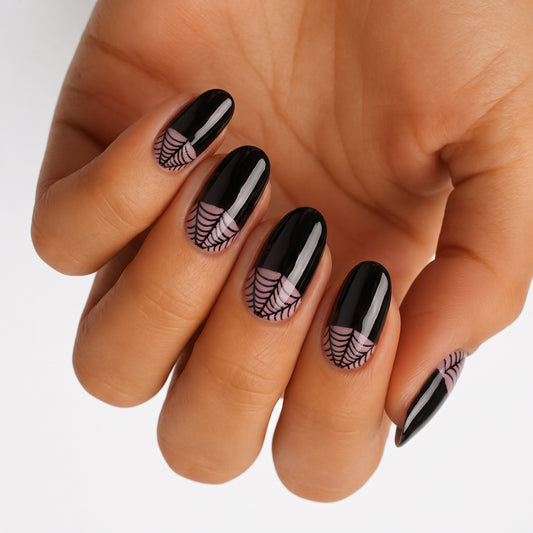 Glossy black nail wraps with sheer spiderweb tips, oval Halloween press-on nail design.