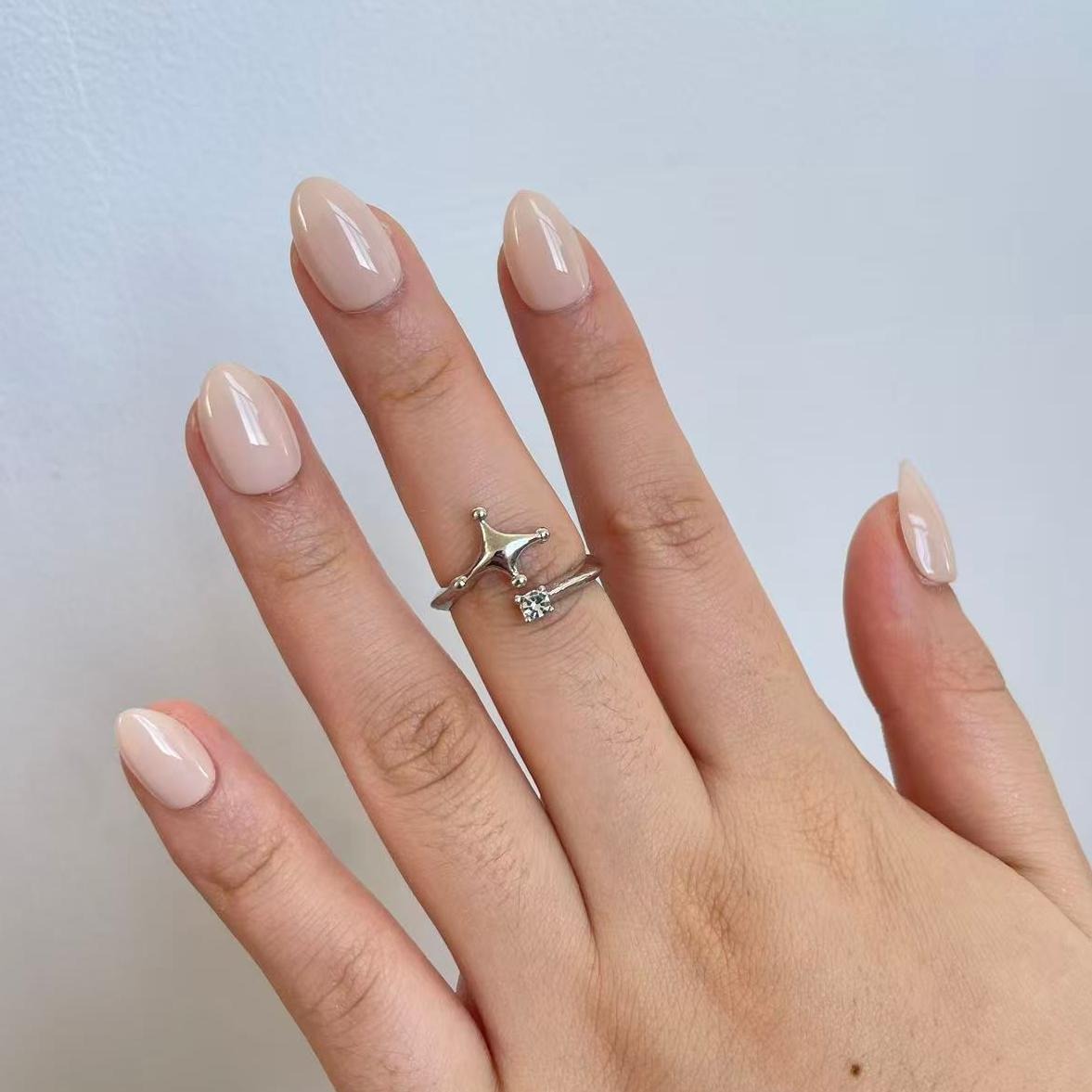 Sheer nude beige glossy semi-cured gel nail wraps on almond-shaped nails.