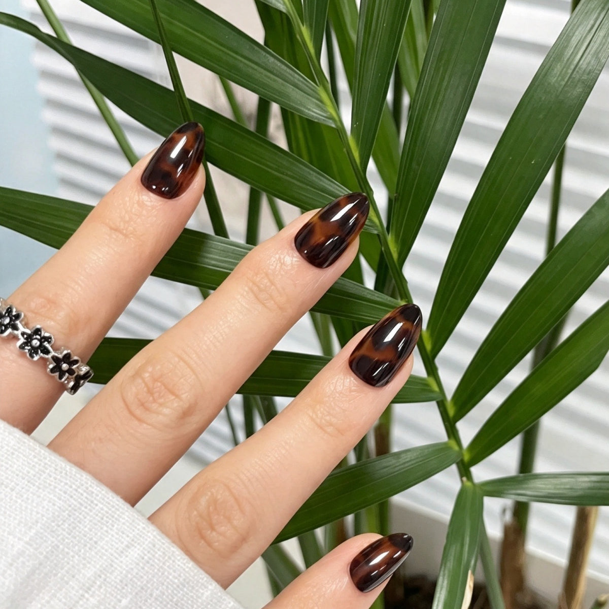 Glossy brown tortoiseshell pattern on short almond soft gel press-on nails