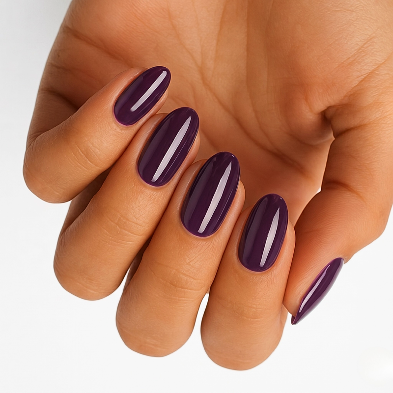 Deep aubergine purple nail wraps on hand with glossy elegant finish