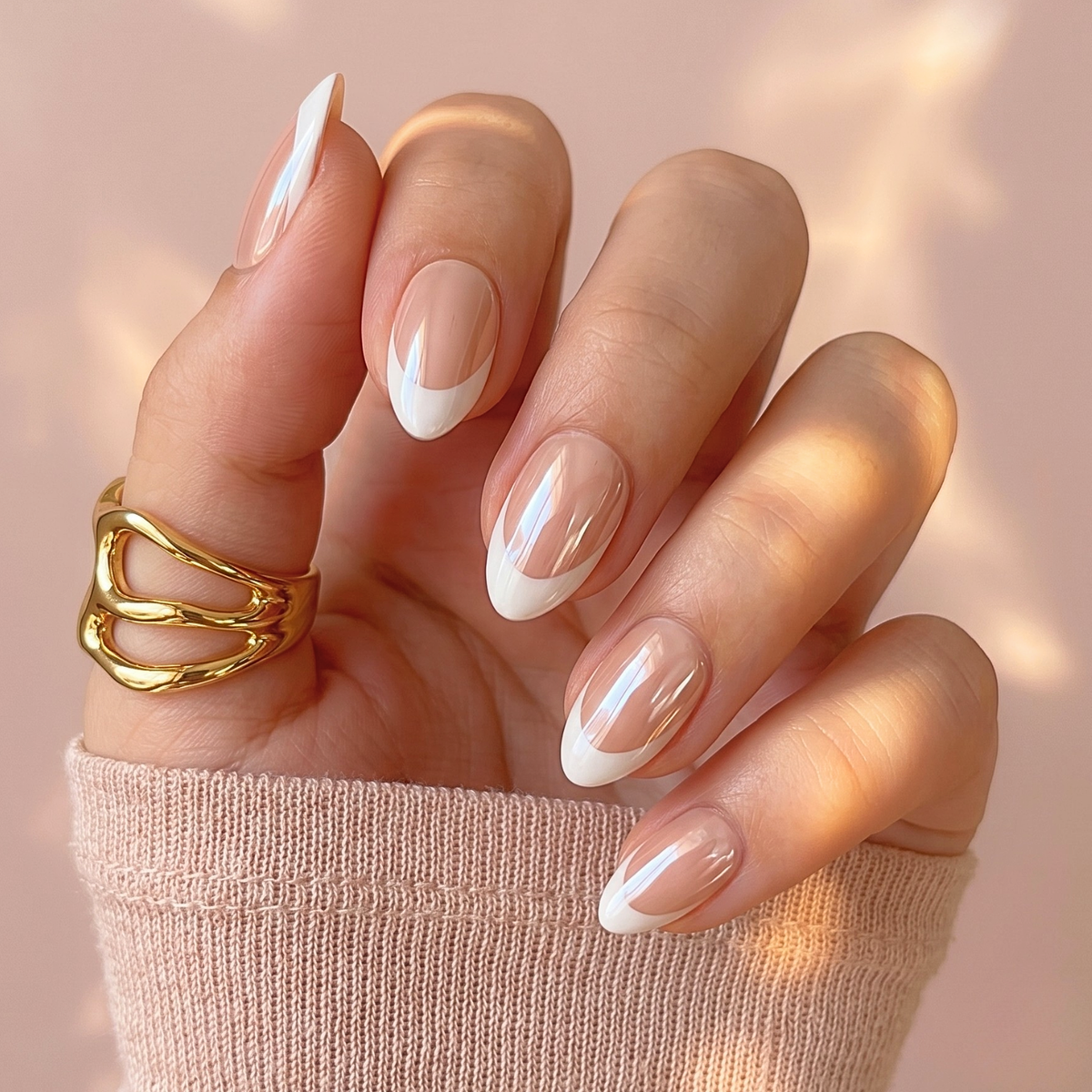 Glossy nude press-on nails with white French tip design on almond shape