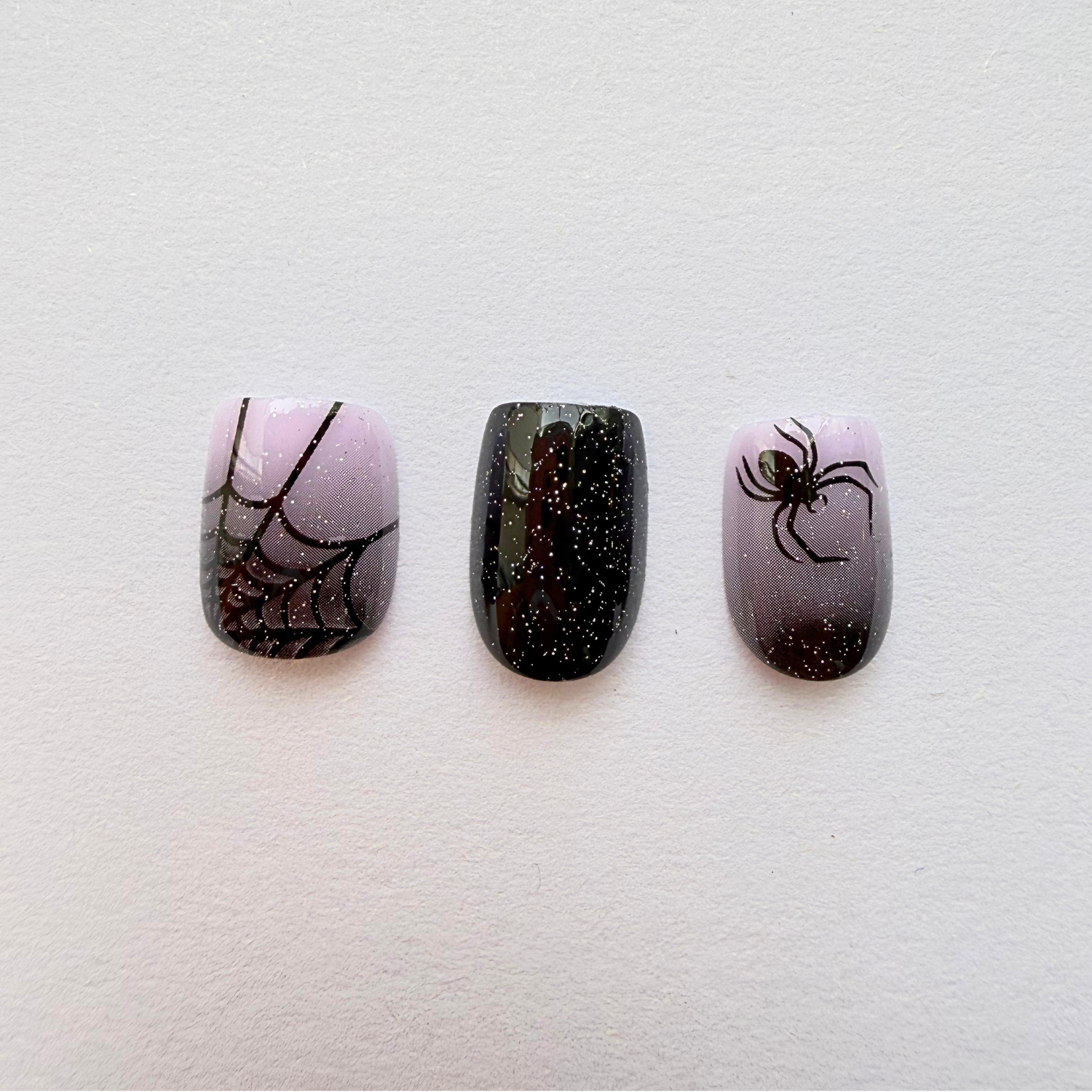 Press-on nails with black glitter ombré, spiderweb and spider Halloween design