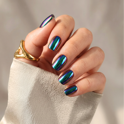 Oil-slick chrome nail wraps, dark green-blue metallic finish with iridescent rainbow shimmer.