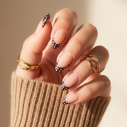 Almond press-on nails with brown French tips and white polka dot accents
