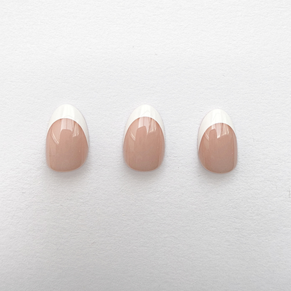 Glossy nude press-on nails with classic white French tips, short round shape