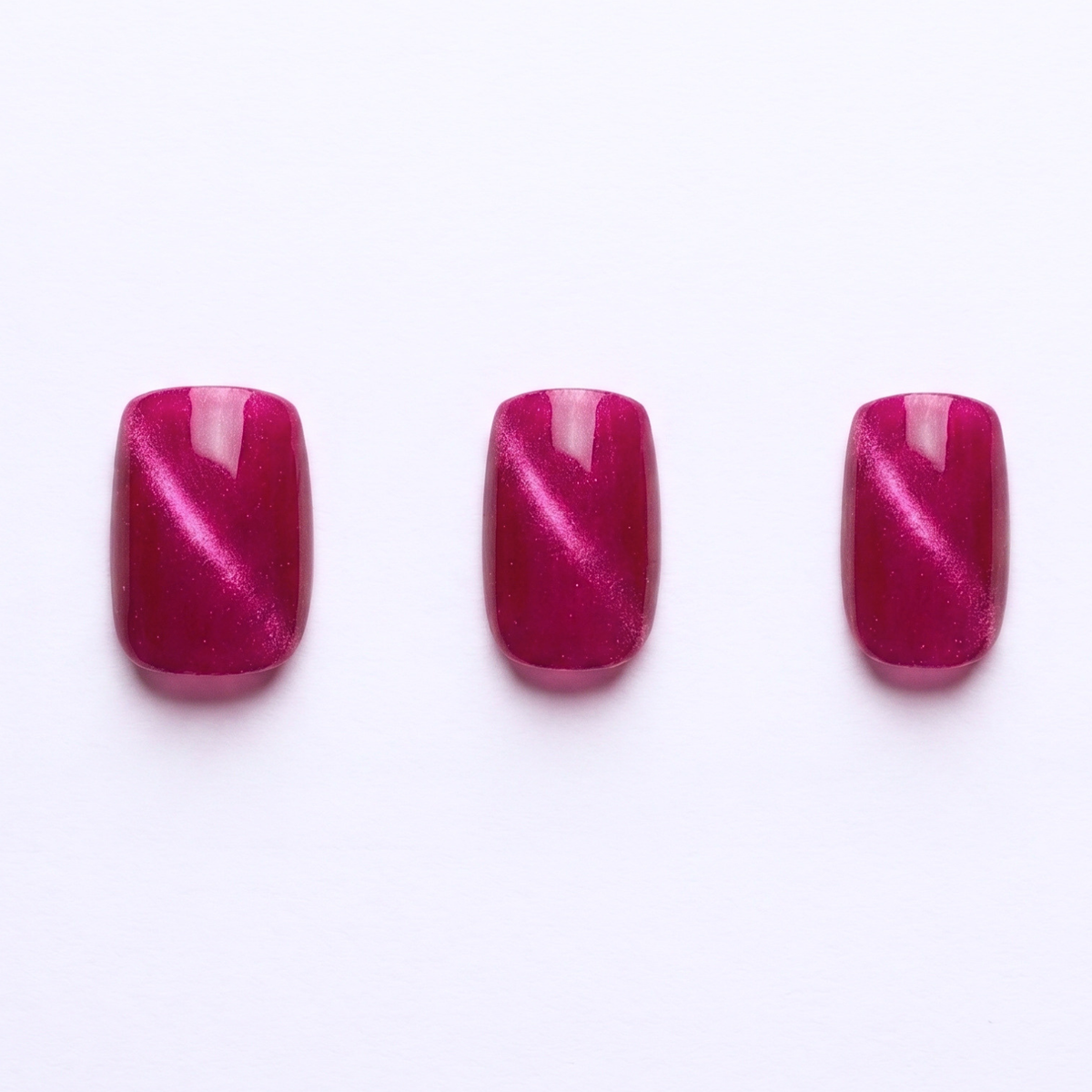 Magenta pink press-on nails with cat-eye shimmer effect, glossy finish