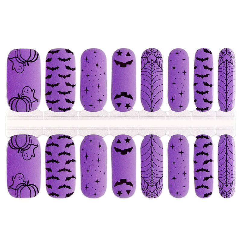 Purple nail wraps with black Halloween prints: bats, ghosts, pumpkins, spiderwebs and stars