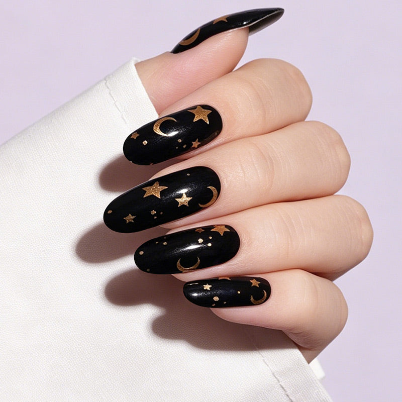 Glossy black press-on nails with gold moon and star celestial design, almond shape