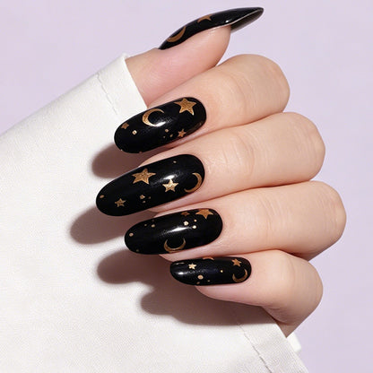 Glossy black press-on nails with gold moon and star celestial design, almond shape