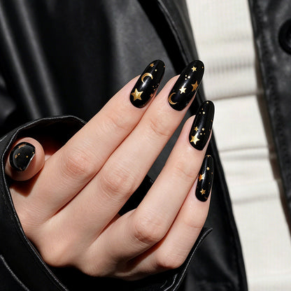 Glossy black press-on nails with gold star and moon celestial design, almond shape