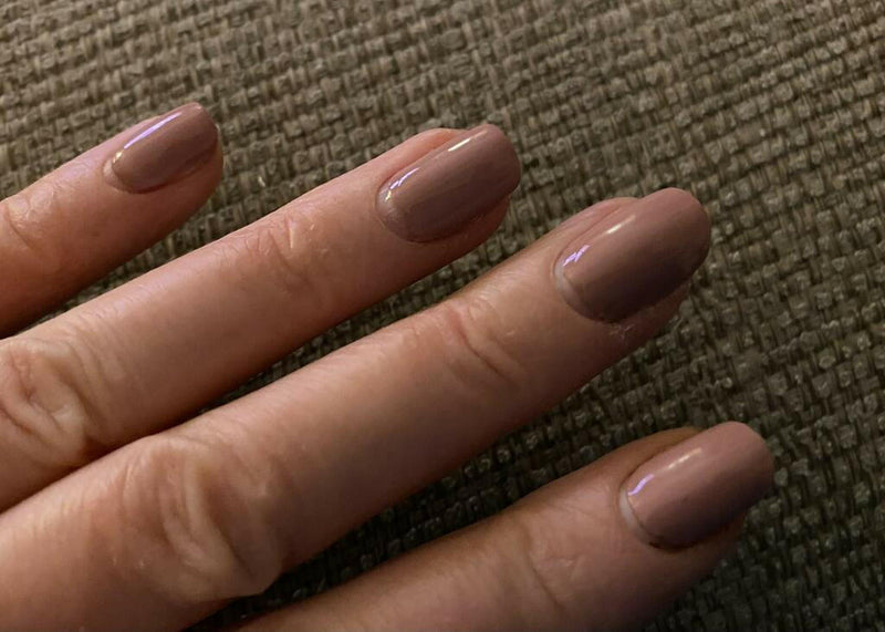 Blush pink glossy gel nail wraps on hand showing nude manicure finish