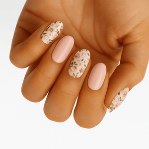 Hand displaying nude pink gel nail wraps with delicate floral pattern at-home manicure