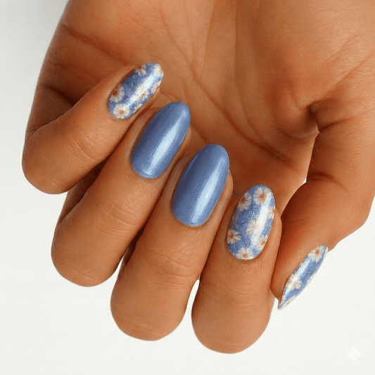 Blue gel nail wraps with white daisy floral pattern displayed on hand for spring nail art