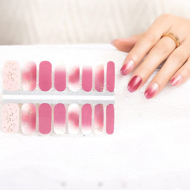 Hand wearing pink gradient nail wraps with sparkle accents