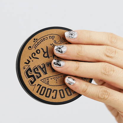 Silver metallic butterfly gel nail wraps displayed on hand over circular wooden surface