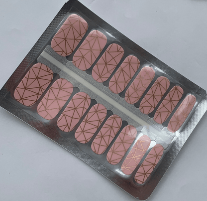 Pink geometric nail wraps with gold metallic lines in packaging strip