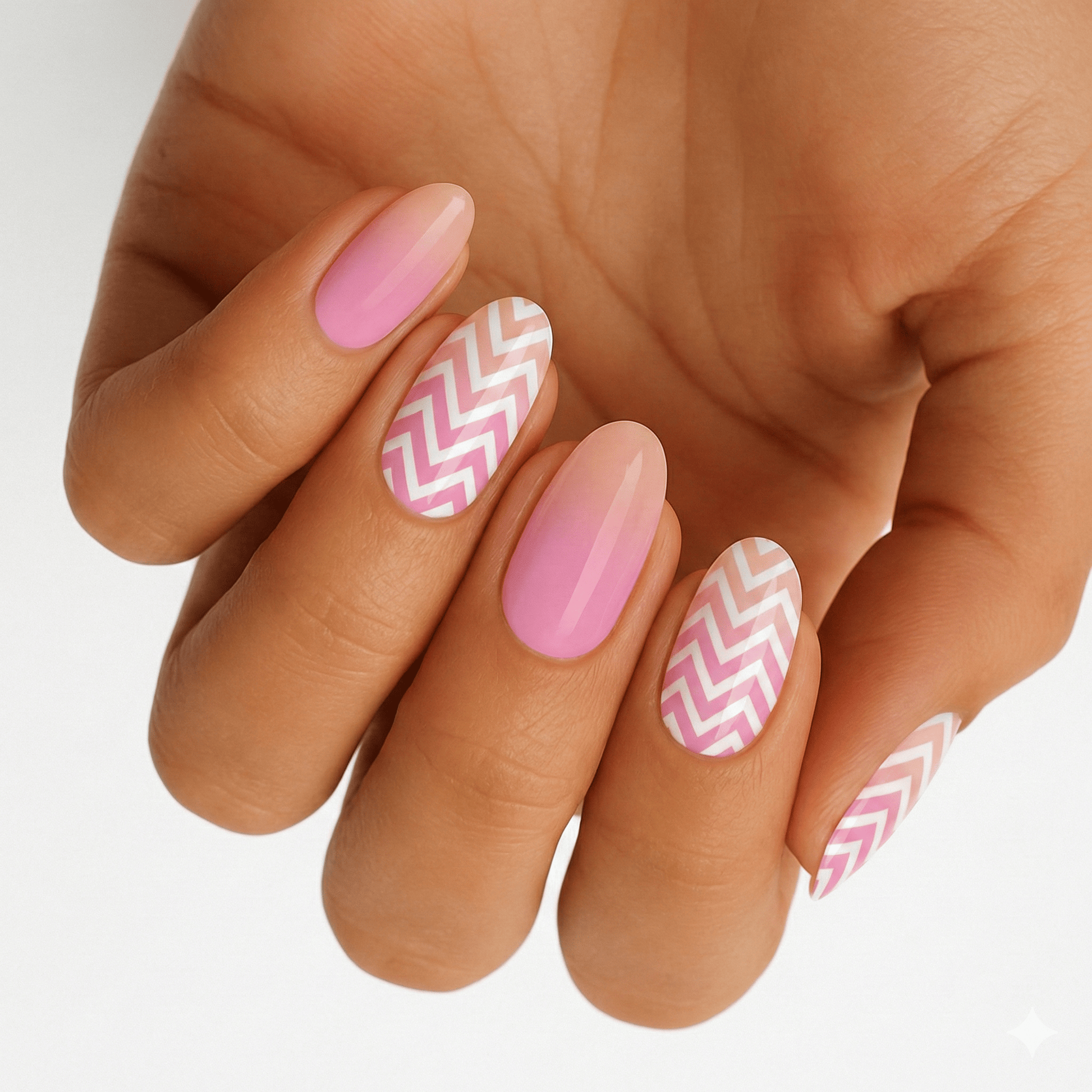 Pink and white chevron pattern nail wraps on hand showing geometric nail art design