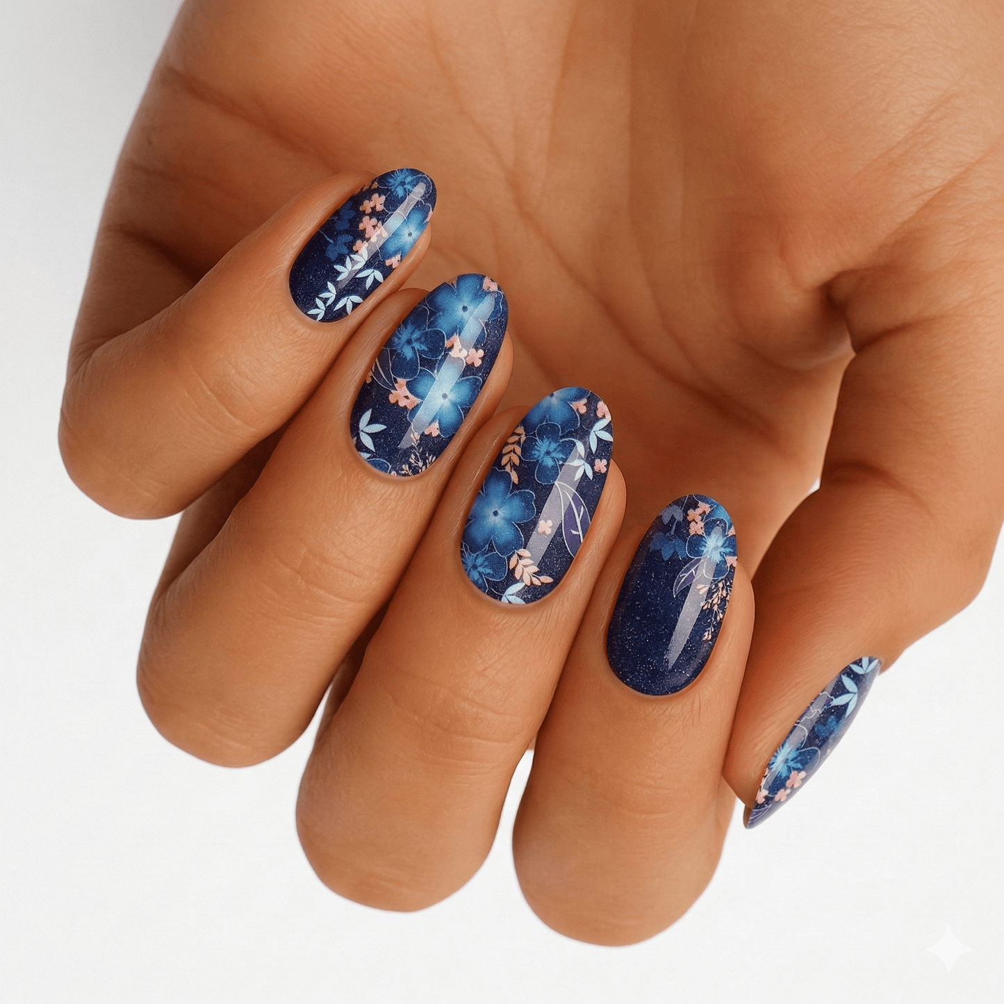 Blue tropical floral nail wraps on hand showing watercolour botanical design