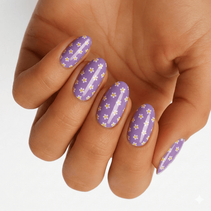 Purple glitter nail wraps with yellow buttercup flowers worn on hand