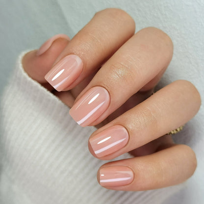 Short square press-on nails in glossy nude pink with glazed chrome finish on hand