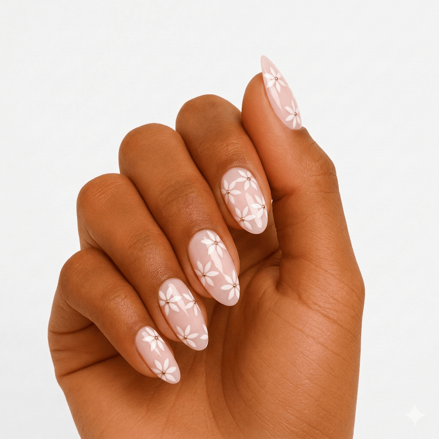 Pink floral gel nail wraps with white daisy pattern on dark skin hand
