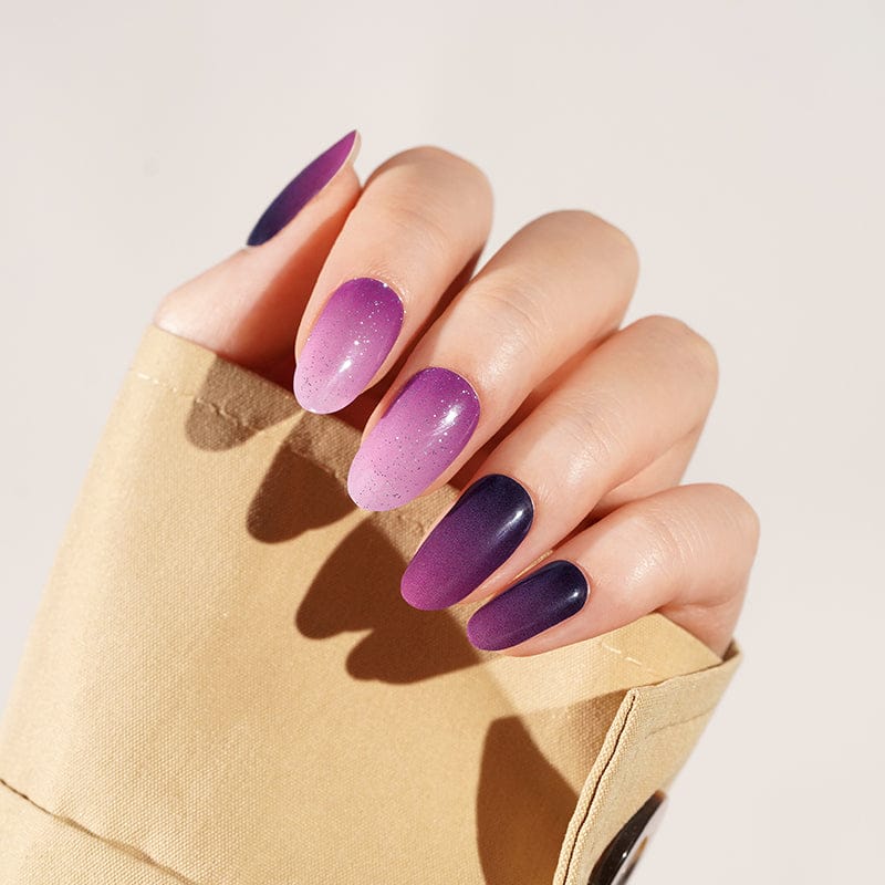 Purple ombre gel nail wraps on hand displaying gradient manicure finish