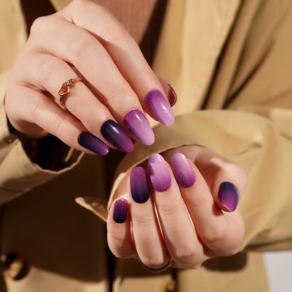 Purple ombre gel nail wraps on hands showing gradient from dark plum to lavender